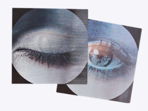 Two square stickers with circular close-up artwork of a closed eye on the left and an open eye on the right