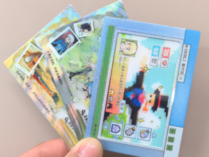 Hand holding a fan of rectangular pixel-art arcade game stickers