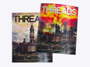 Two overlapping rectangular stickers titled THREADS depicting a quiet city street and a fiery explosion scene